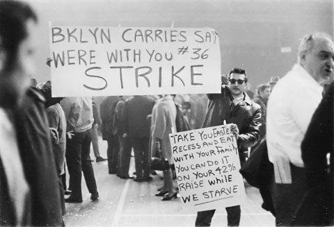 Workers on strike holding signs that say "BKLYN CARRIES SAY WE'RE WITH YOU #36 STRIKE."
