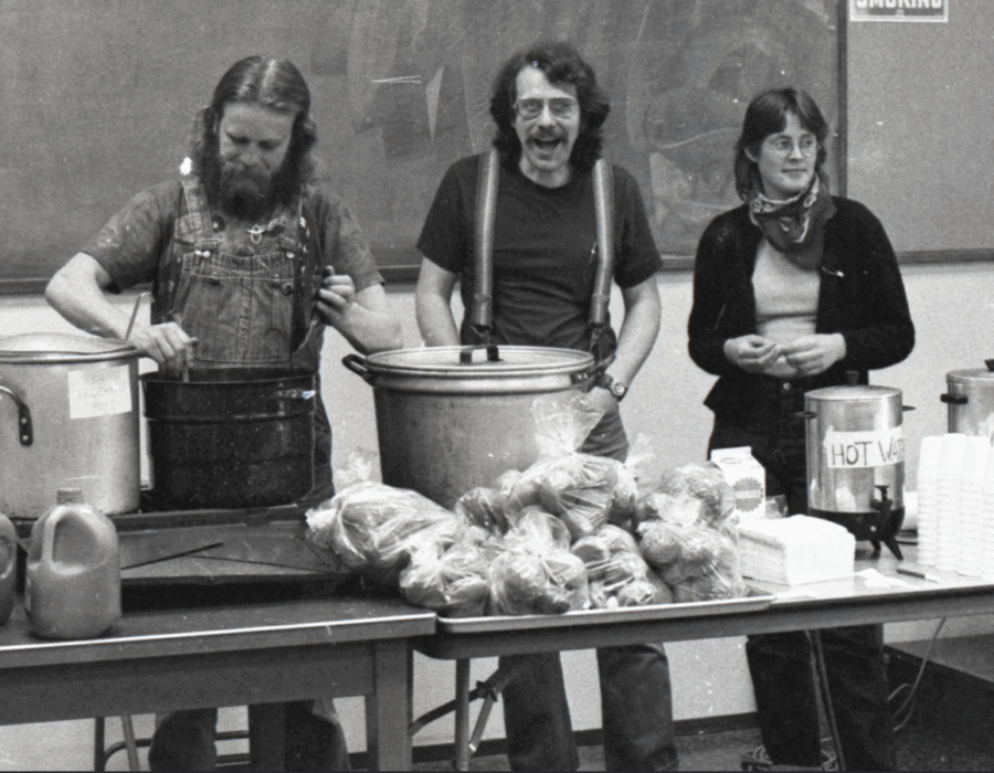 Fellow Workers David Helm, Scott Slaba, and Mary Thurtle serve food from a table. Food for People Soup Kitchen, Bellingham IWW. From the IWW Materials Preservation Project.