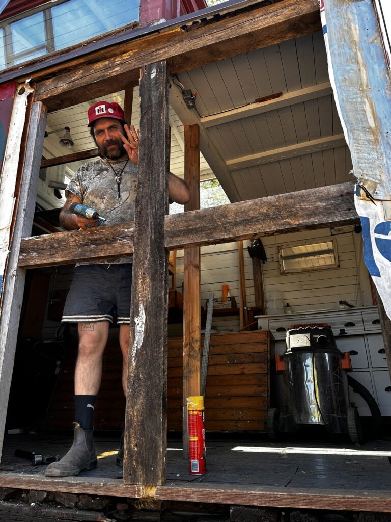 Brendan stands behind a rotted wood frame of the flanger. Brendan Phillips